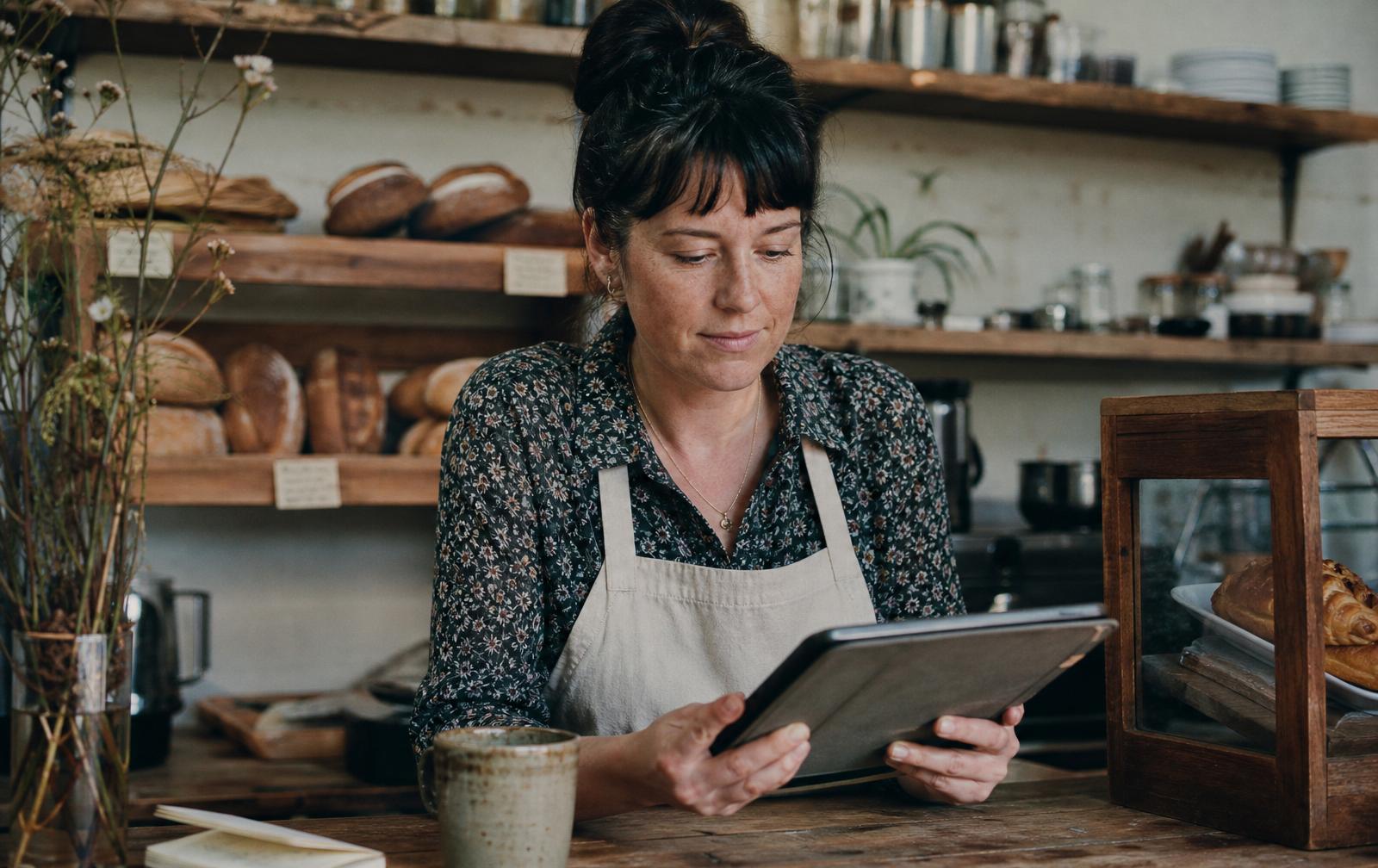 Small business owner reviewing finance options on a tablet at her cafe counter